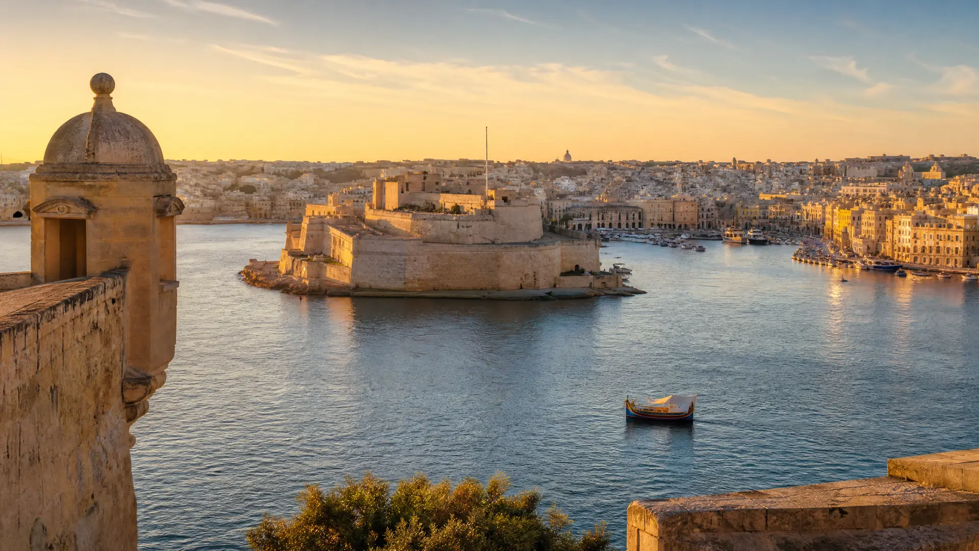 Grand Harbour in Malta at golden hour with Fort St Angelo and the Birgu waterfront across the water