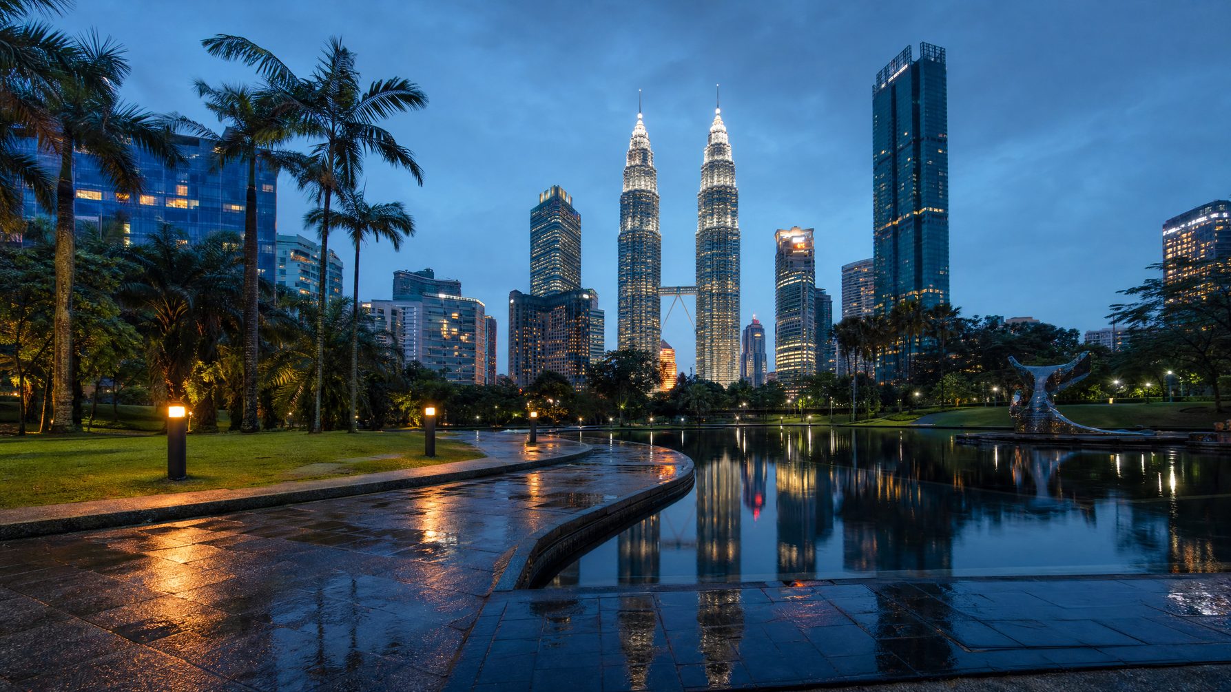 Kuala Lumpur skyline reflected after tropical rain at blue hour